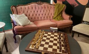 Vaaleanpunainen retrosohva ja shakkilauta Lobby Myyrmäen loungetilassa