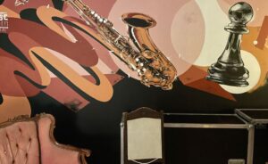 Lobbyn loungen seinämaalaus, jossa saksofoni ja shakkinappula